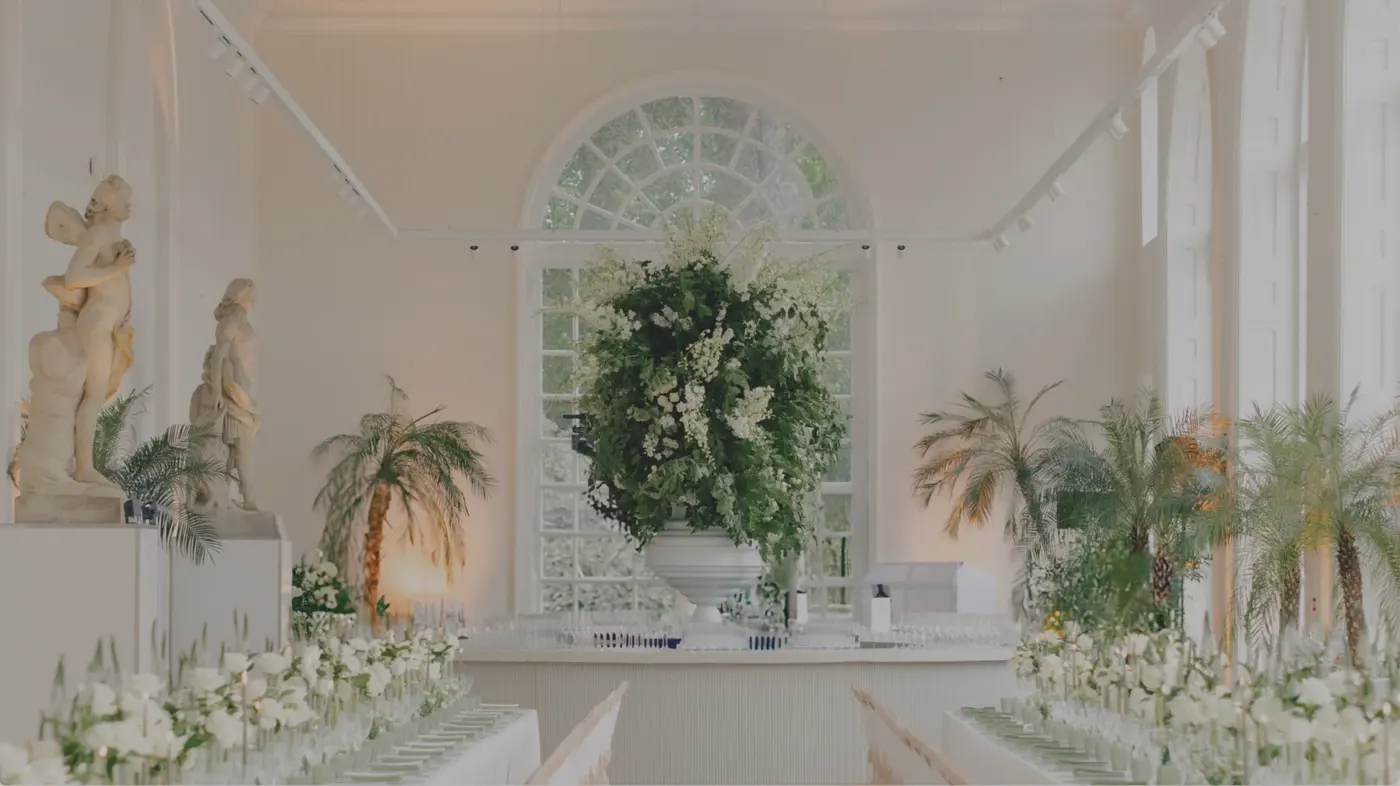 Sculptural white and green wedding flowers beneath an arched window at Kew Gardens
